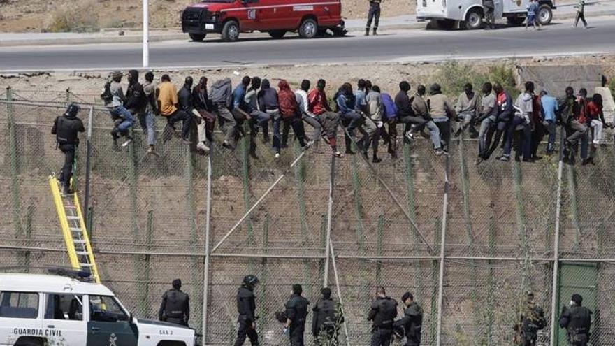 Unos 80 inmigrantes se encaraman a la valla durante horas tras un nuevo asalto