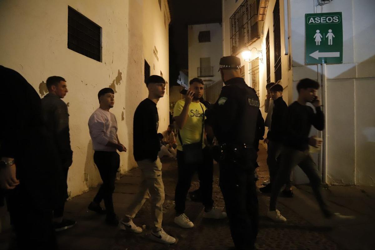 Un agente de Policía conversa con unos jóvenes en el entorno de una de las cruces.