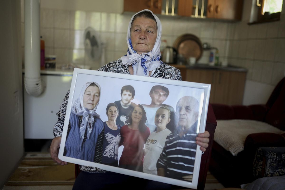 Sefika Mustafic, de 72 años, posa con una fotografía de familiares víctimas del genocidio de Srebrenica en su casa cerca de Potocari, en Bosnia.