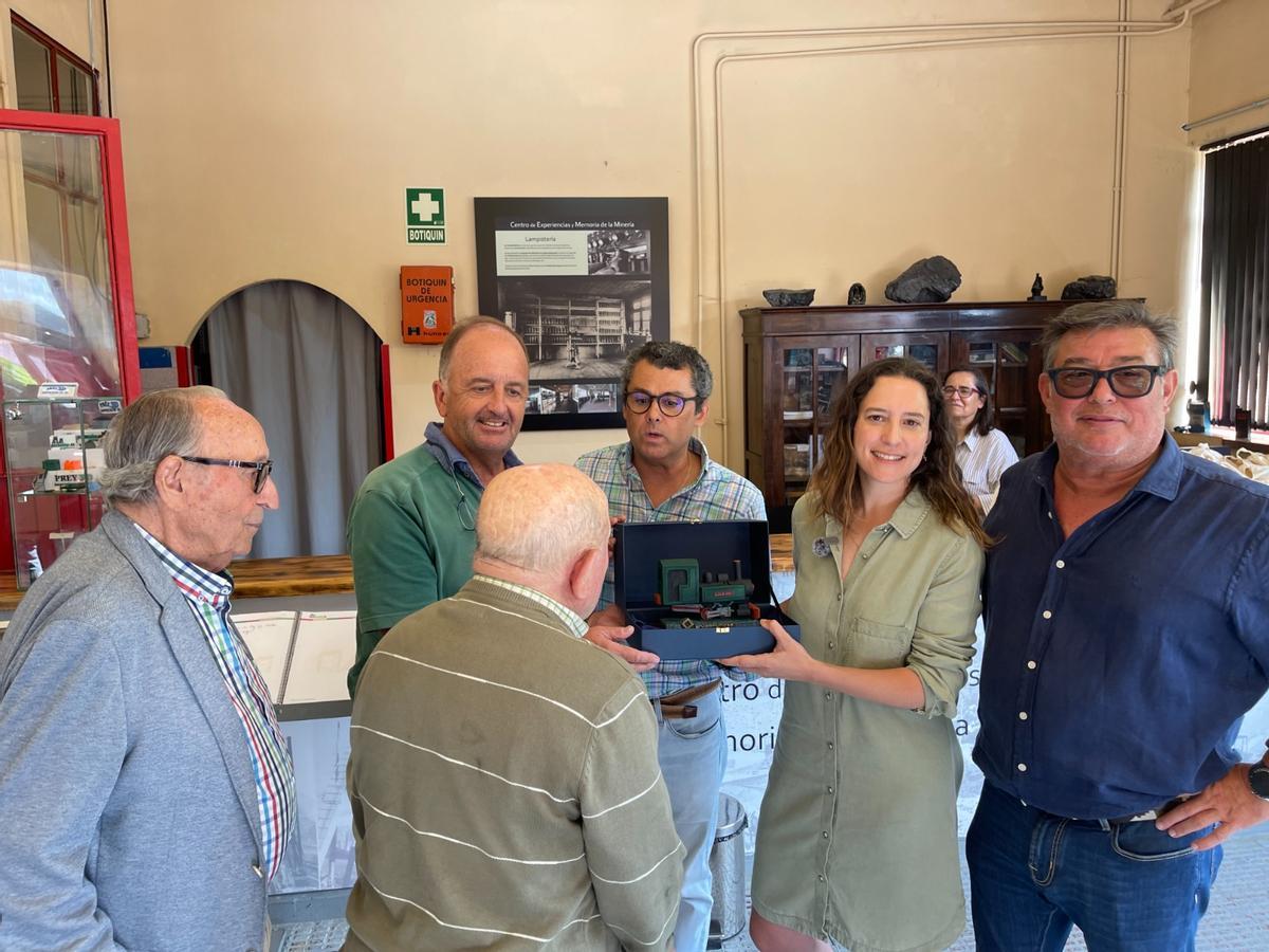 José Luis Augusto, Ángel Fernández (de espaldas), Benigno Tomé, Gustavo Pañeda, Elisa Alonso y Celso Ordiales, con una maqueta de la locomotora.