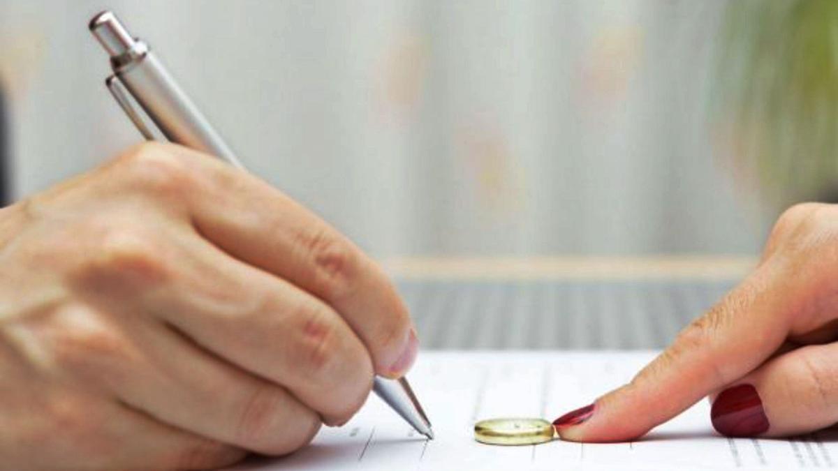 Una pareja firma los papeles de su separación.