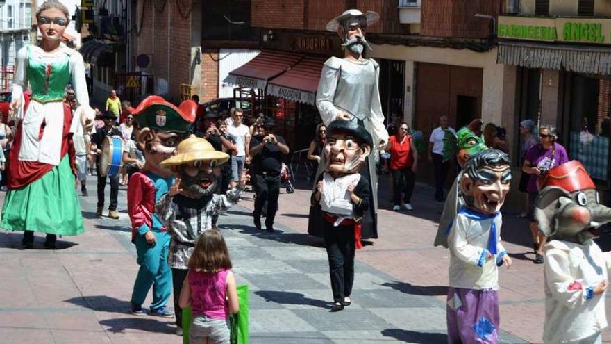 Gigantes y cabezudos, seguidos de público, desfilan por el centro de la ciudad ayer por la mañana.