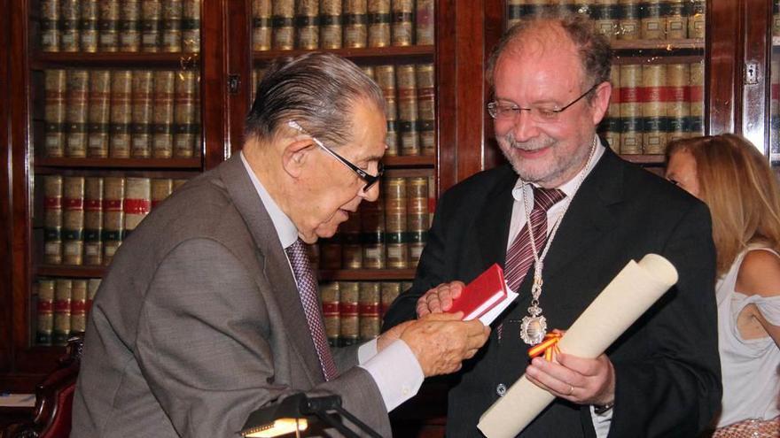 Juan Velarde hace entrega a Leopoldo Tolivar de un diploma y una medalla de la Academia.