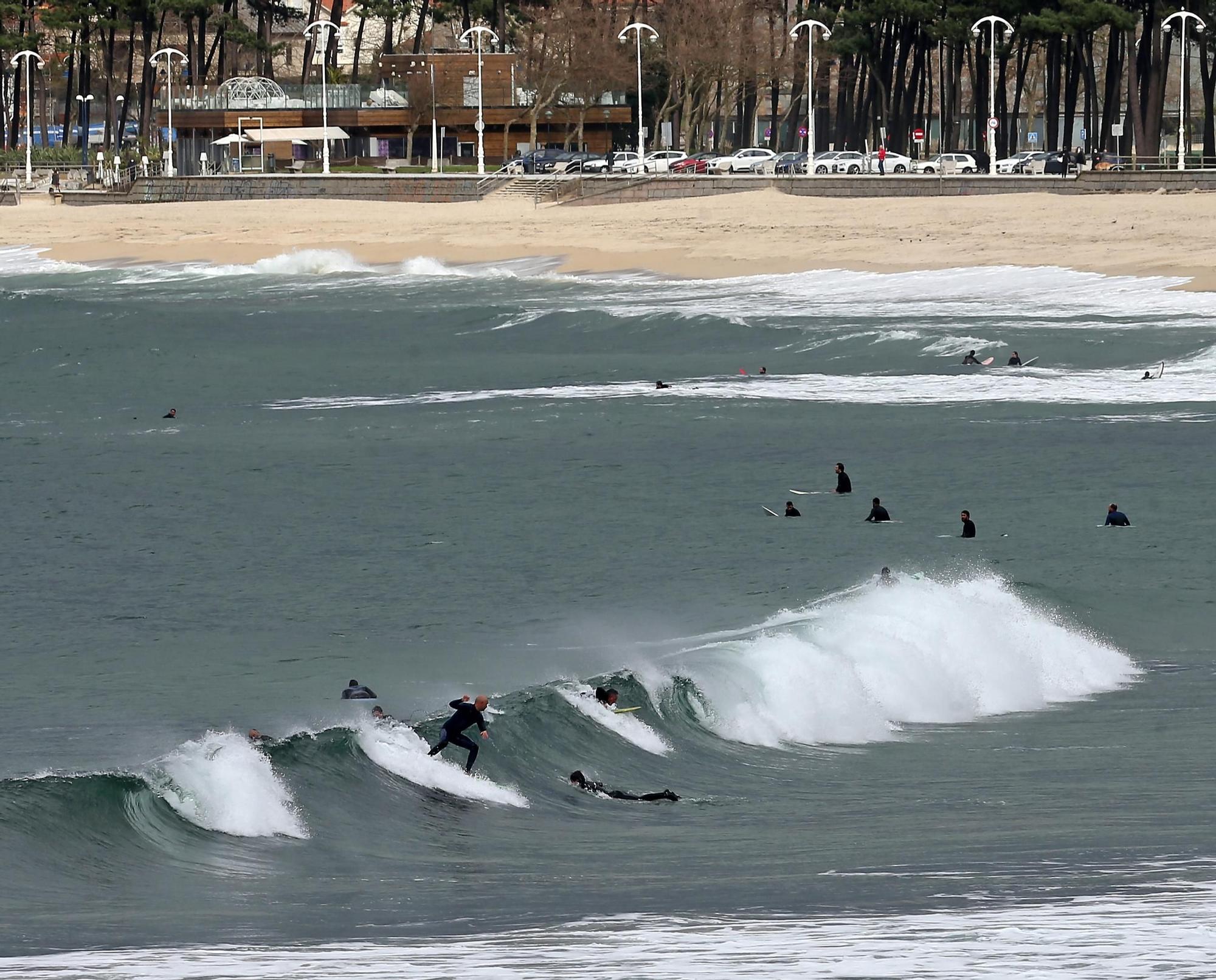 Surfistas practicando  junto a la desembocadura del río Lagares y la playa de Samil