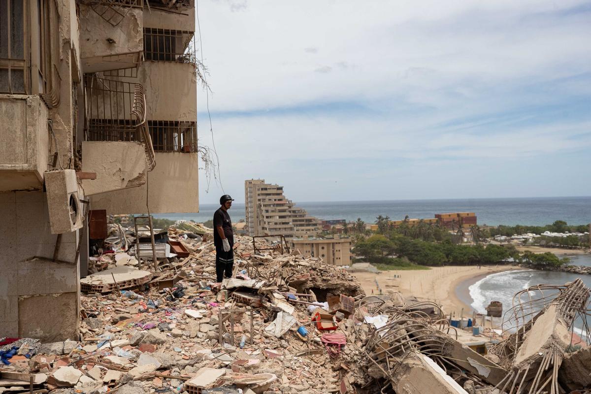 Un rescatista observa escombros en una zona afectada por los terremotos, este domingo, en Catia La Mar (Venezuela). EFE/ Ronald Peña R
