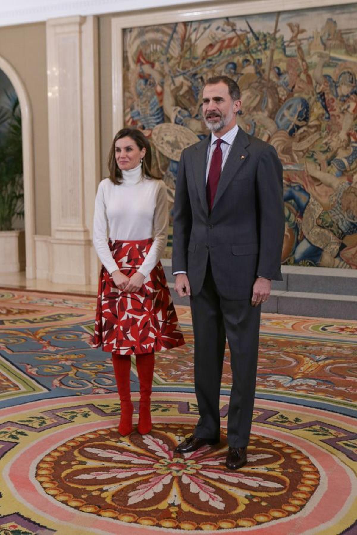 Letizia Ortiz con jersey, falda estampada y botas de color rojo junto a Felipe VI