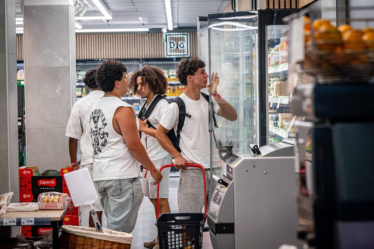 Turistas jóvenes surtiéndose en un supermercado en el barrio de La Mina, en Sant Adrià de Besòs.