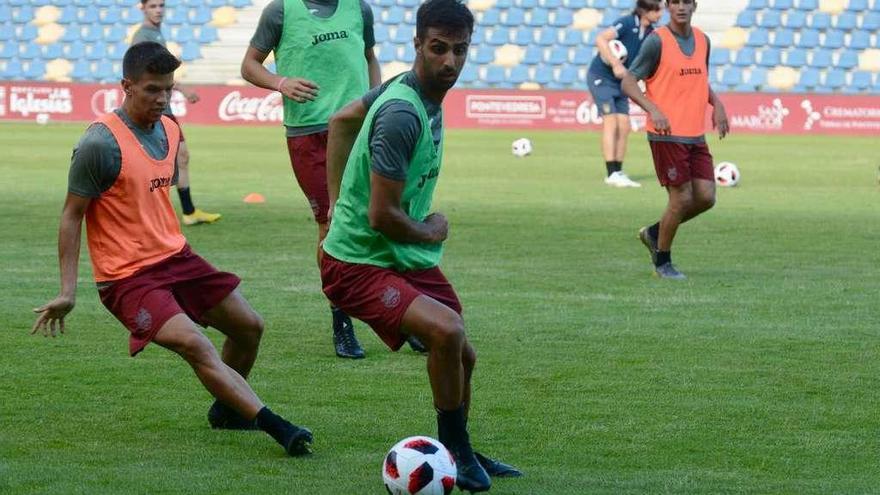 Romay protege la pelota ante la presión de Antón en un entrenamiento de este verano en Pasarón. // Rafa Vázquez