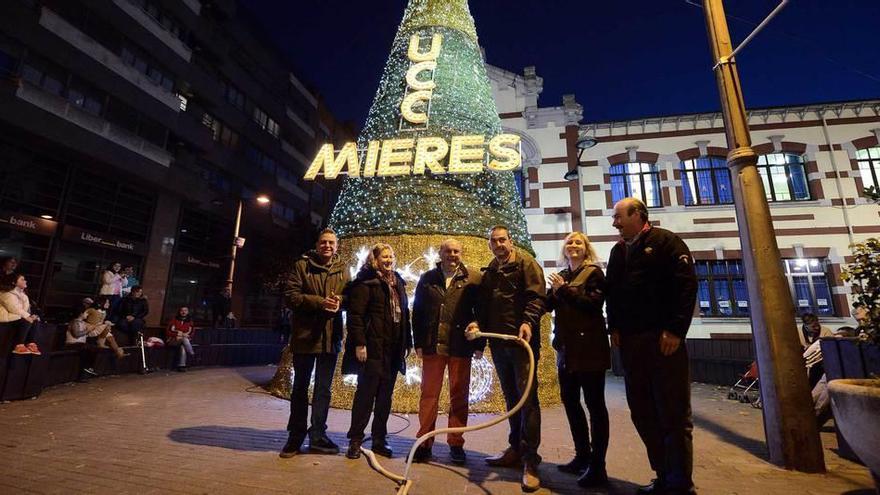 Representantes de la Unión de Comerciantes del Caudal y del Ayuntamiento, en el momento de encender el alumbrado navideño de Mieres.