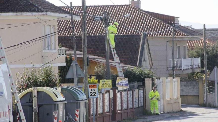 Arriba, trabajos de mejora de la iluminación, ayer. Dcha., vecinos de Tirán, protestando en el paso de peatones. // S.A./G.N.