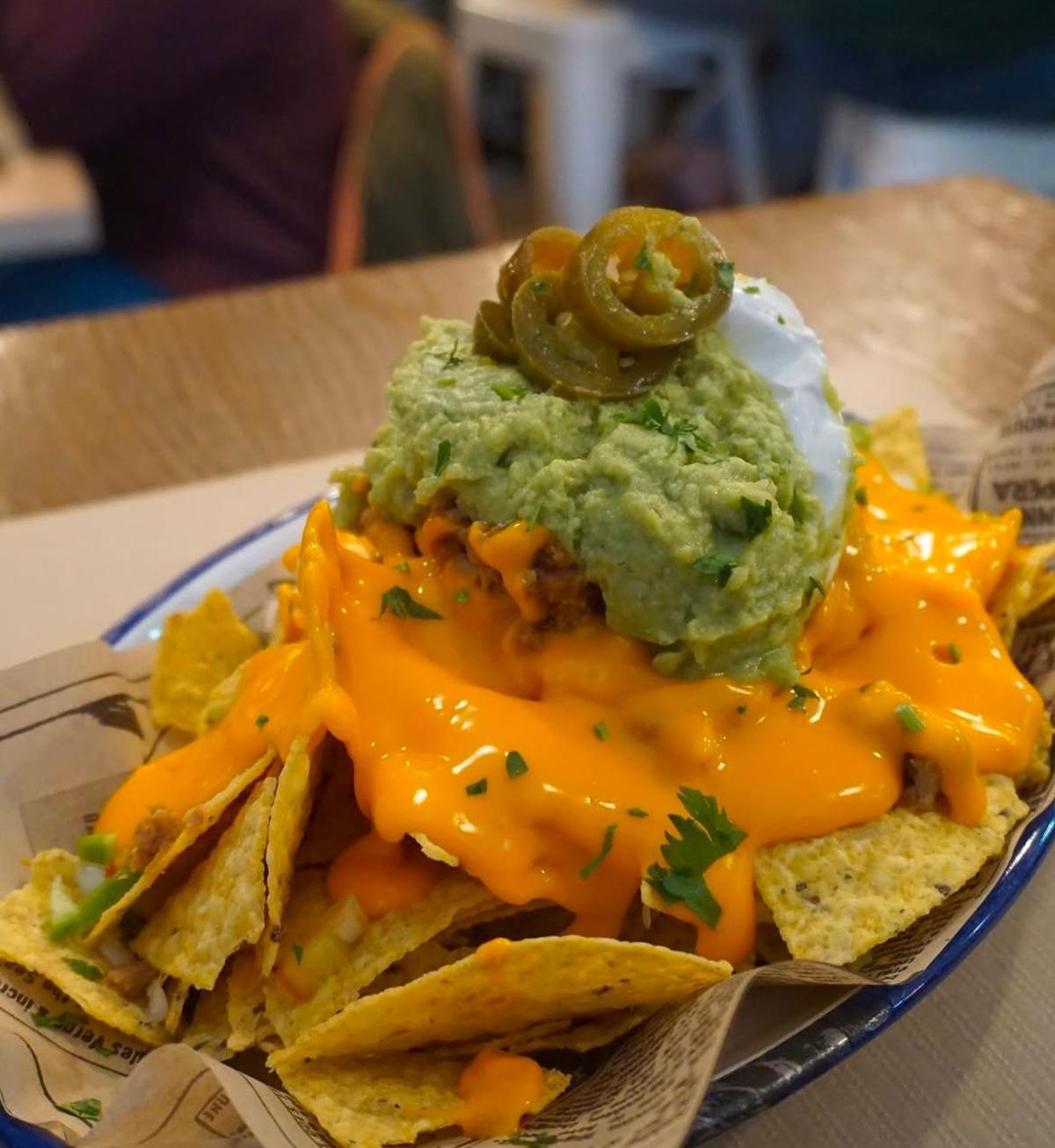 Los nachos acompañados de chili con carne, guacamole, salsa cheddar, pico de gallo, crema agria y jalapeños del Alierta 19