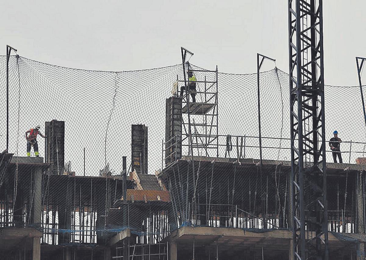 Trabajadores de la construcción levantan un edificio.