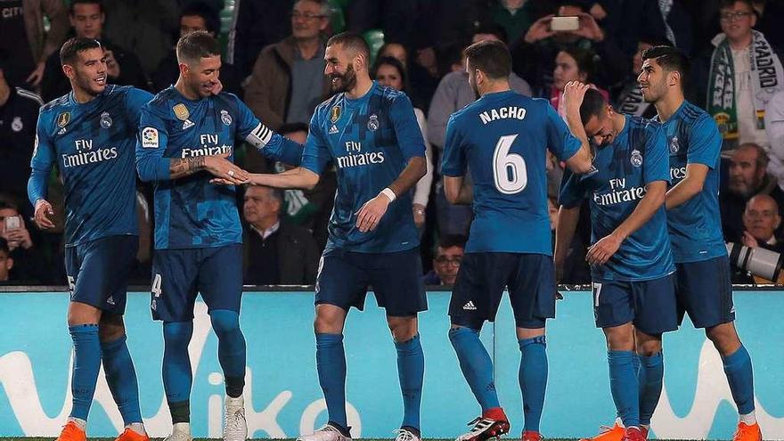 Los jugadores del Real Madrid felicitan a Karim Benzema, autor del quinto gol del conjunto blanco en el Benito Villamarín. // Reuters
