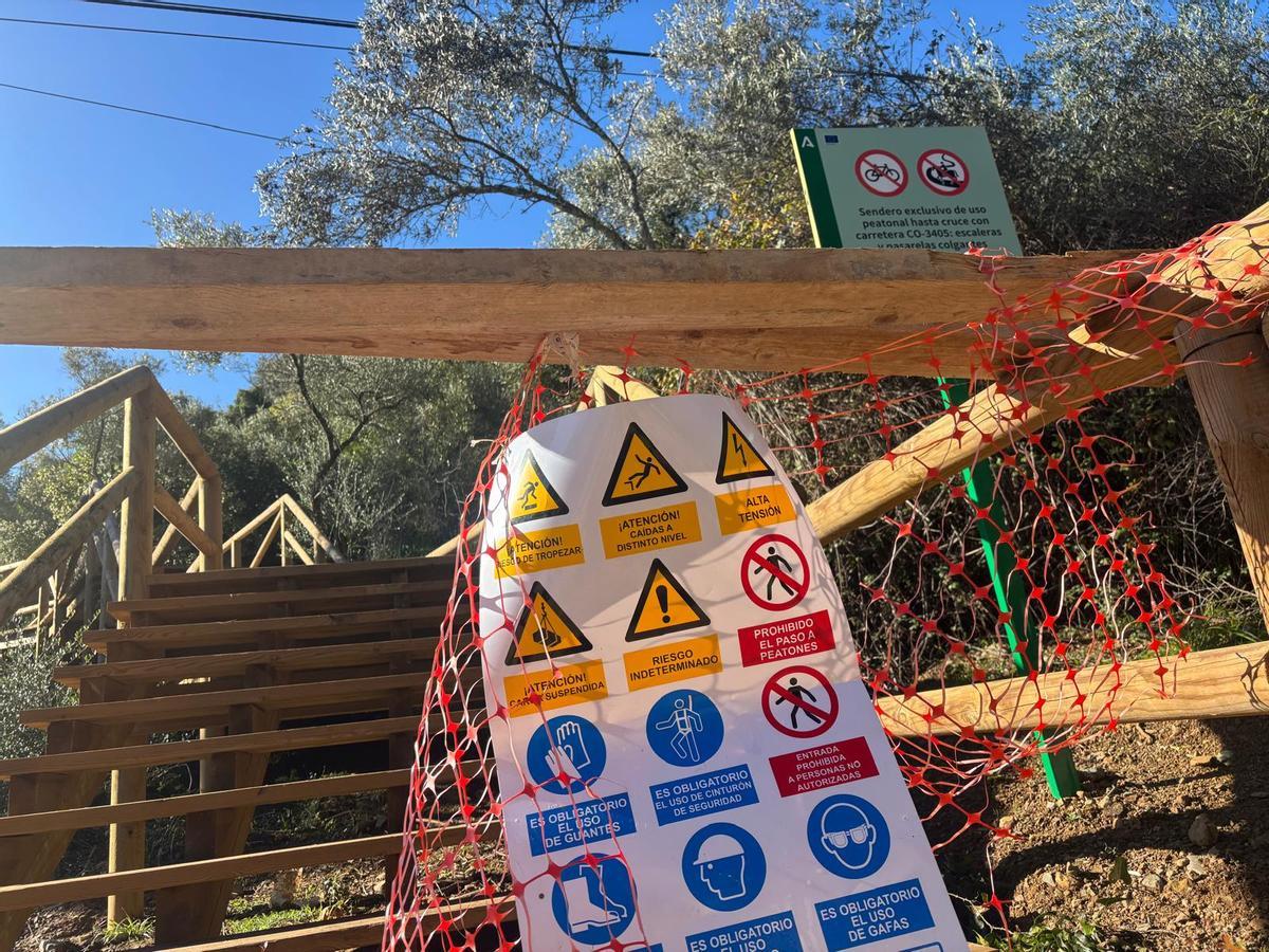 Malla plástica arrancada en uno de los accesos a los puentes colgantes.