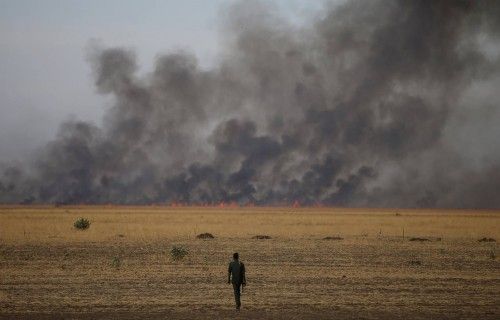 A rebel fighter walks in front of a bushfire in a rebel controlled territory in Upper Nile State