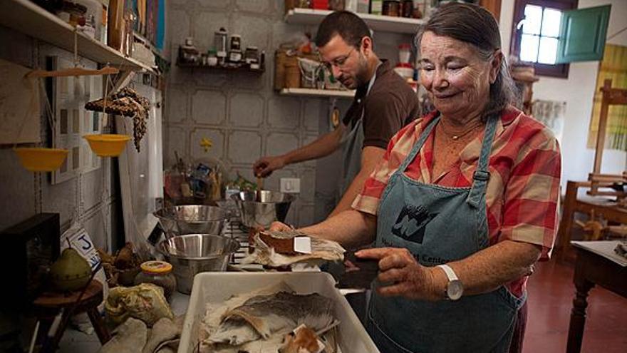 Nilia, ayer, con restos de piel de cabra por teñir; detrás, Daniel prepara un tinte con hongos. i JOSÉ CARLOS GUERRA