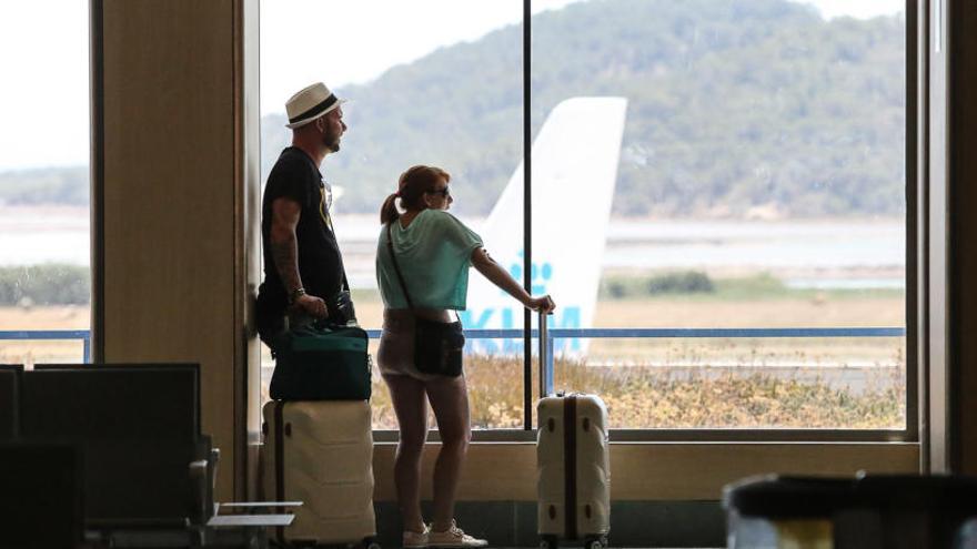 Dos turistas este verano en el aeropueryto de Ibiza.