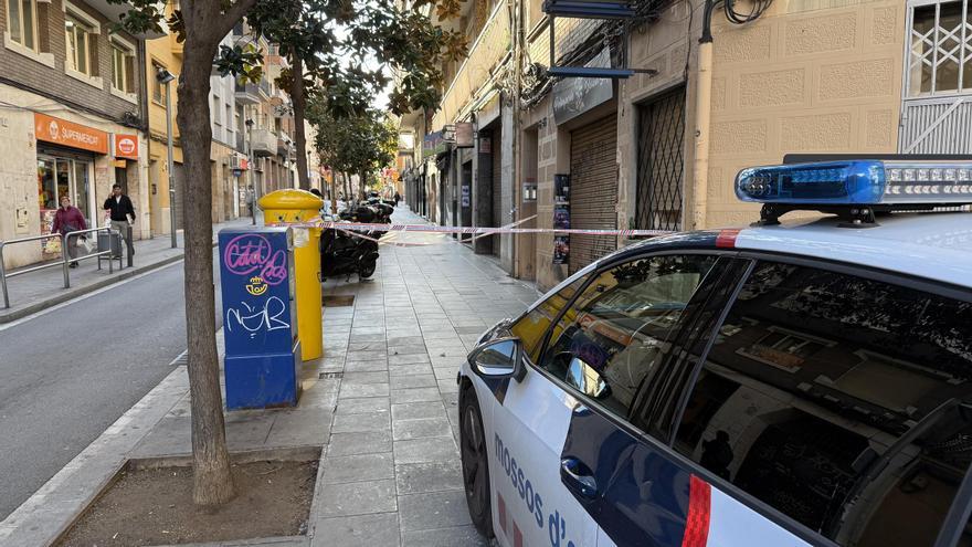 Un vehicle de Mossos al carrer Llobregat de l'Hospitalet, on una dona ha mort en caure per la finestra de casa seva