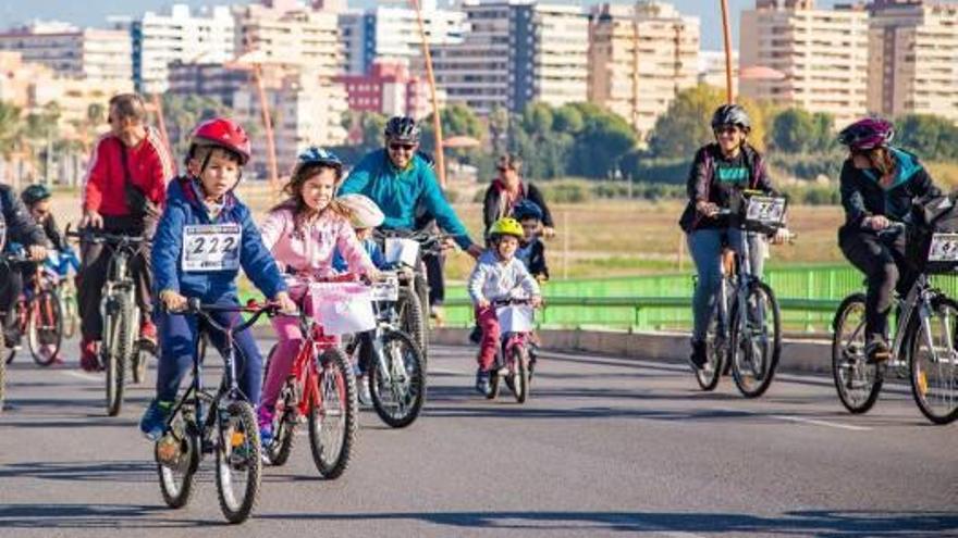 Un grupo de ciclistas atraviesa el Puente de la Bega de Cullera durante la Volta Popular.