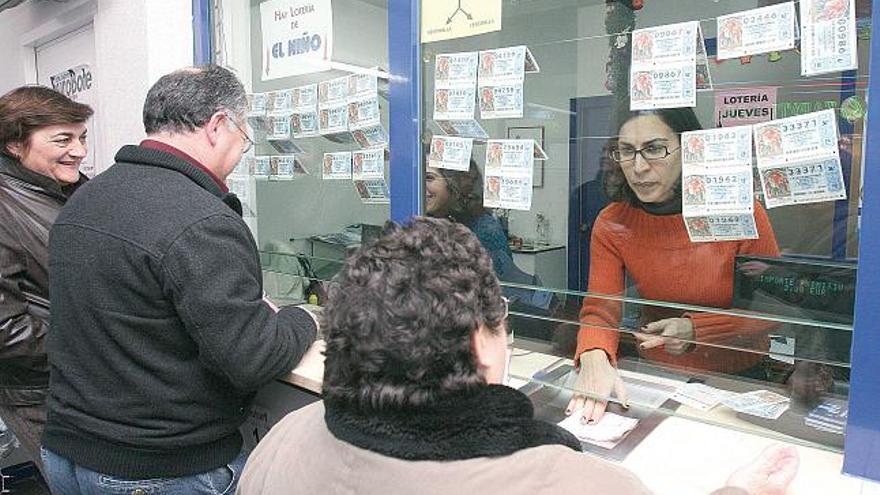 Un grupo de personas adquiere lotería en una de las administraciones de Vigo.