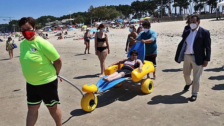 El alcalde, junto a una de las sillas anfibias en Samil. 