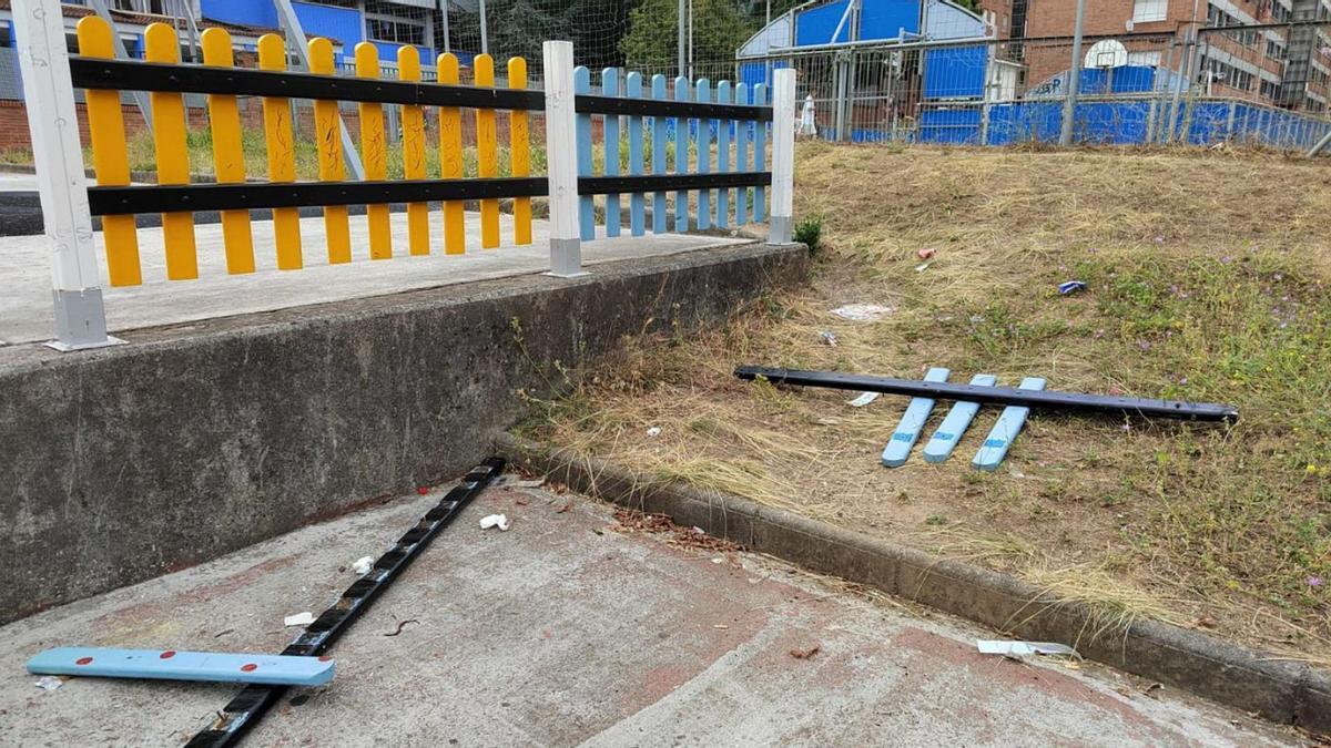 La valla rota en el parque infantil ubicado en el distrito de Riaño.