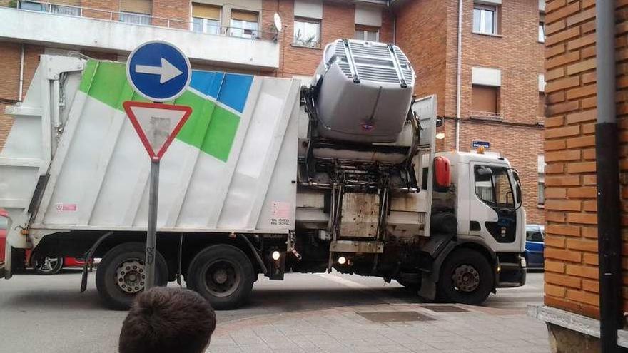 Un camión recoge un contenedor en Vega de Arriba, Mieres.