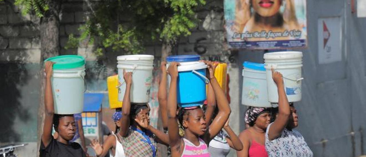 Un grupo de haitianas cargan cubos con agua para suplir los cortes de suministro, el pasado septiembre en Puerto Príncipe.