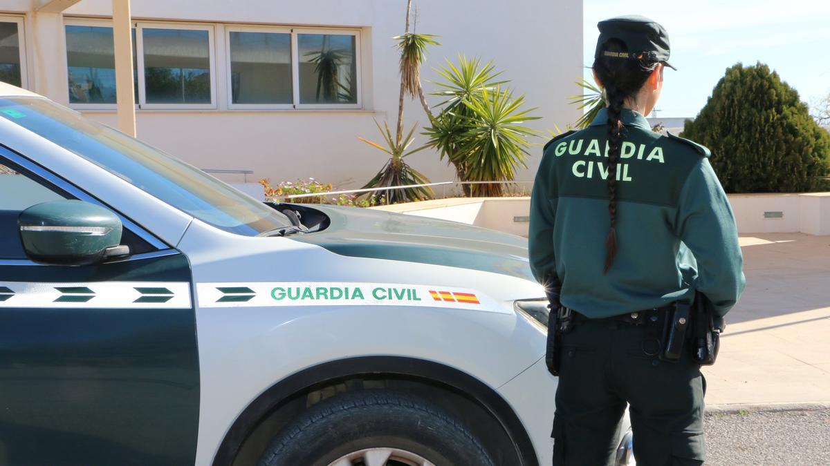 Agente de la Guardia Civil junto a un vehículo