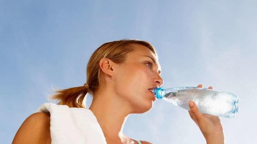 Una deportista bebe un botellín de agua.