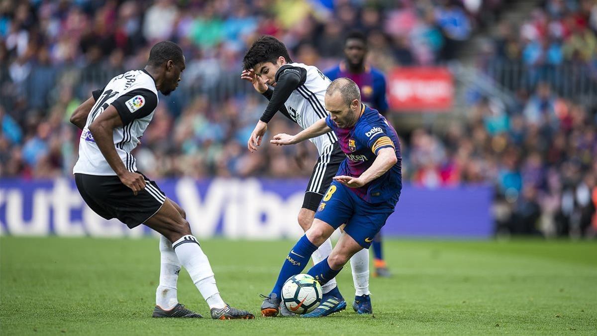 Iniesta se marcha de Kondogbia y Soler en el Barça-Valencia del Camp Nou.