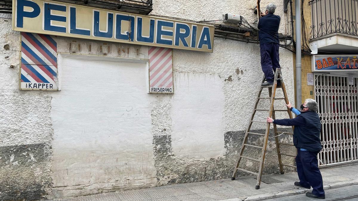 Operarios retiran carteles.