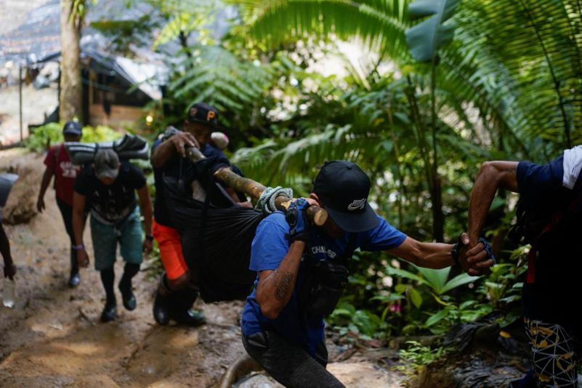 Migrantes cruzan el río Muerto en el Tapón del Darién, de viaje hacia los Estados Unidos, en Acandi, Colombia