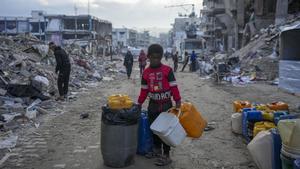 Un joven palestino carga bidones de agua en Jabaliya, Franja de Gaza.