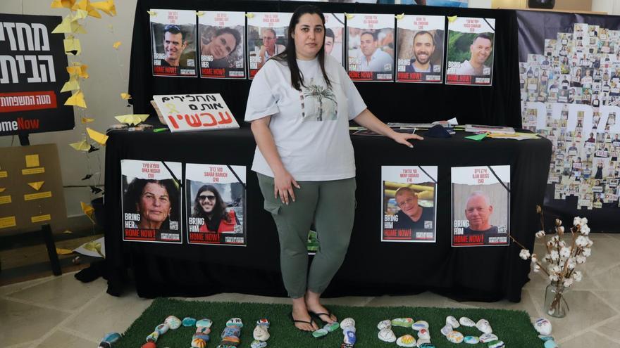 Tzlil Divker posa frente a carteles de rehenes y vecinos del kibutz Beeri que fueron asesinados durante el ataque de Hamás del 7 de octubre.