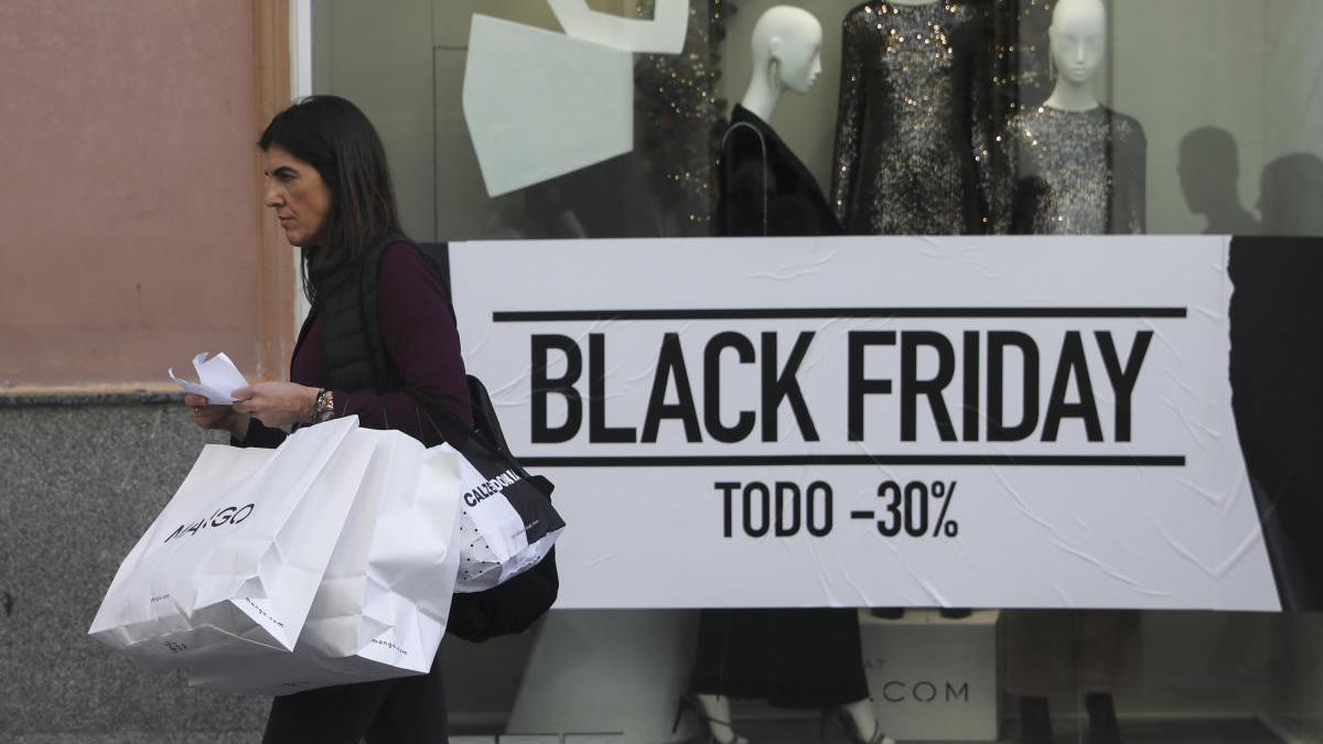 Una mujer camina frente a un escaparate en el Black Friday 2019