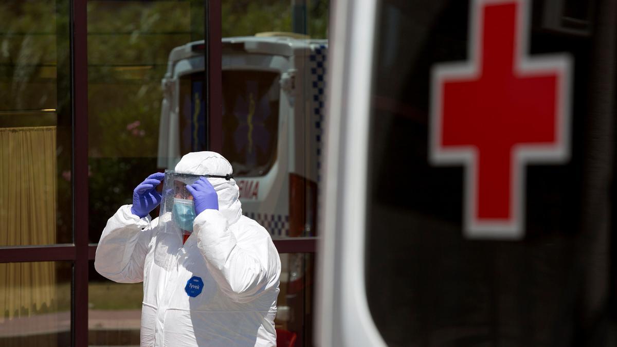 Personal sanitario llega al Centro de Acogida, Emergencia y Derivación de Cruz Roja de Málaga para trasladar a una de las personas afectadas por la COVID-19.