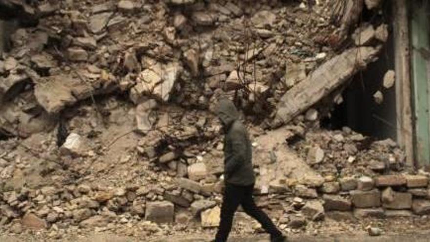 Un home camina pel costat d&#039;un edifici destruït a Alep.