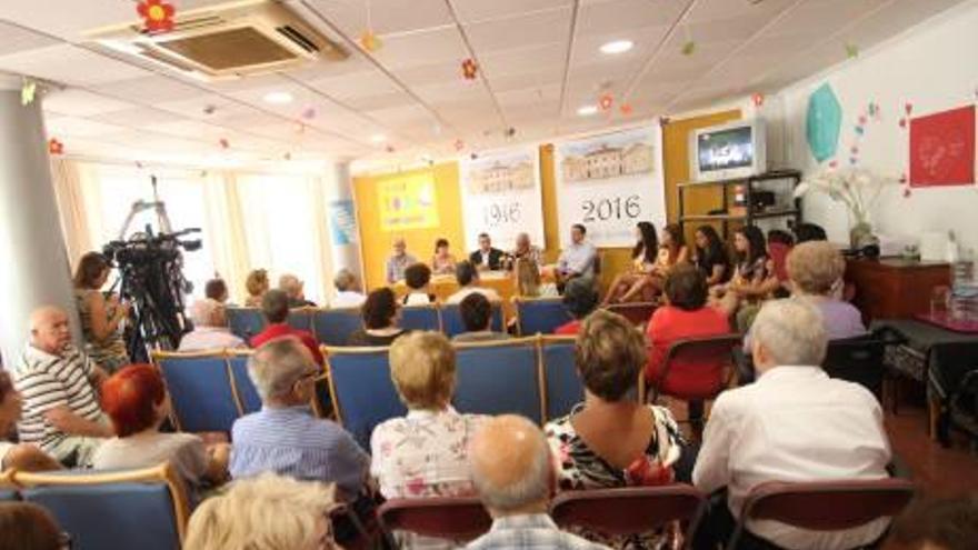 Imagen de los ponentes durante la presentación de la revista conmemorativa por los 100 años de vida del Asilo de Aspe. A la derecha, el público asistente al acto.