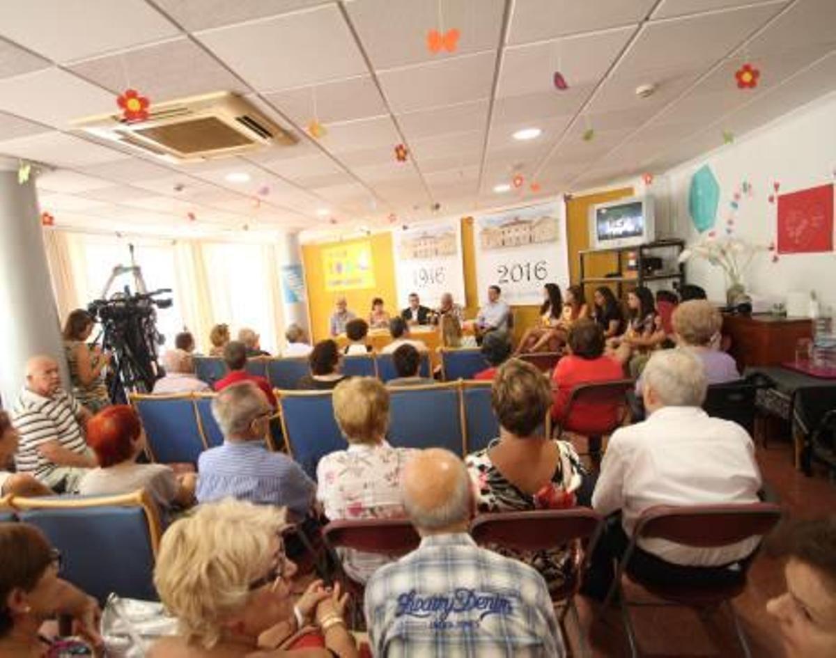 Imagen de los ponentes durante la presentación de la revista conmemorativa por los 100 años de vida del Asilo de Aspe. A la derecha, el público asistente al acto.