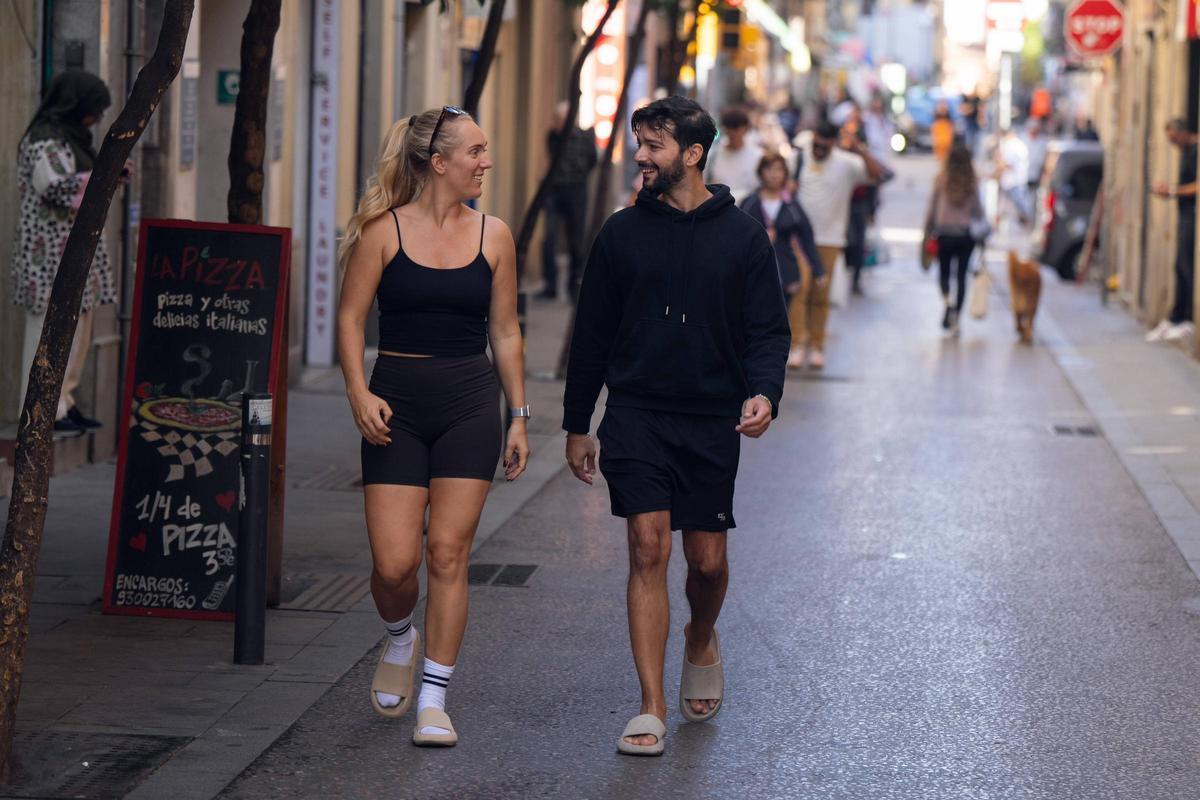Dos personas paseando por una calle de Barcelona.