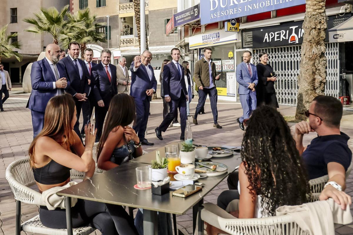 La comitiva de autoridades, con Óscar Puente a la cabeza, saluda a unos ciudadanos sentados en una terraza del nuevo Paseo Marítimo