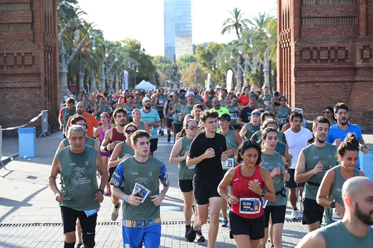 Los participantes en la Cursa de la Mercè a su paso por el  Arco del Triunfo. 