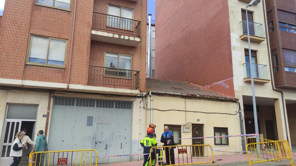 Policía Local y bomberos acordonando el acceso a una vivienda en calle Las Eras, junto al edificio afectado.