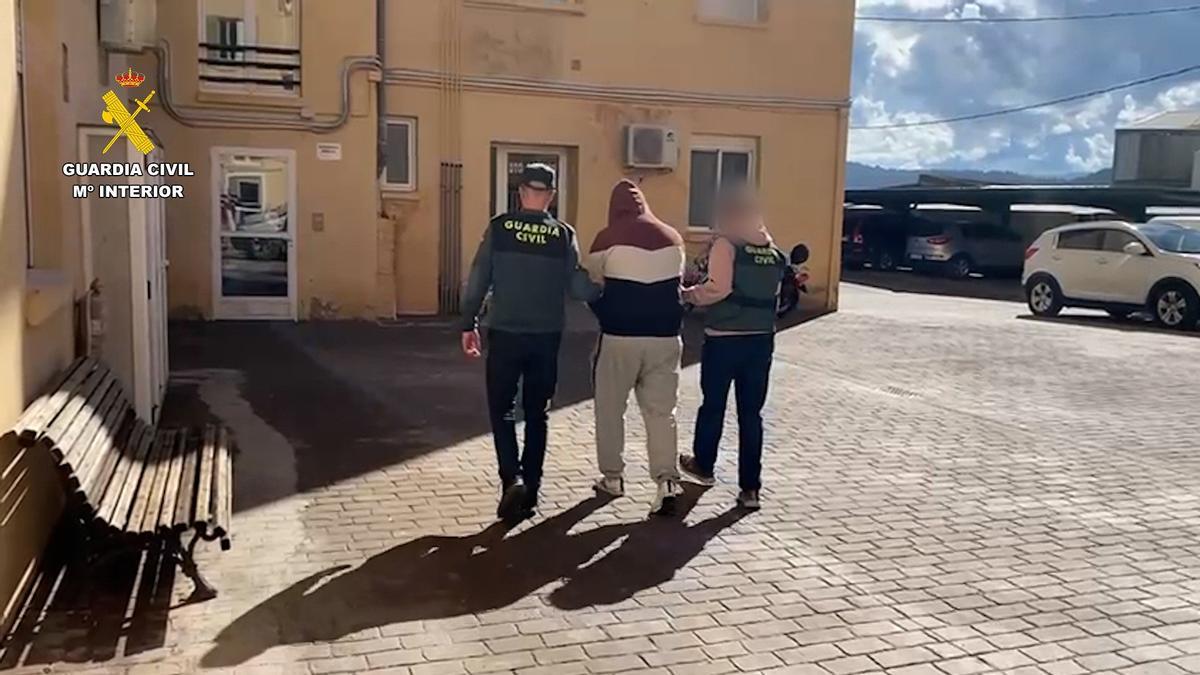 Dos agentes de la Guardia Civil acompañan a uno de los detenidos de una operación que ha permitido destapar cerca de 24 kilómetros de cable de cobre de las obras de la A-30