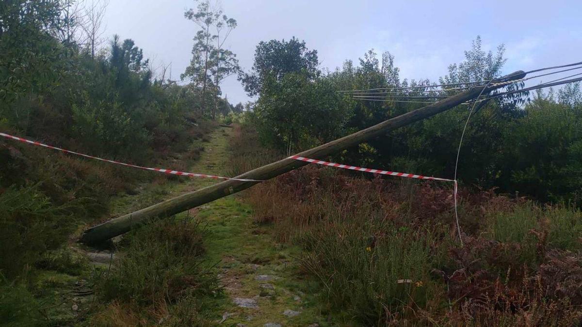 Poste y tendido eléctrico caído sobre el suelo del Trega, con un precinto inservible.