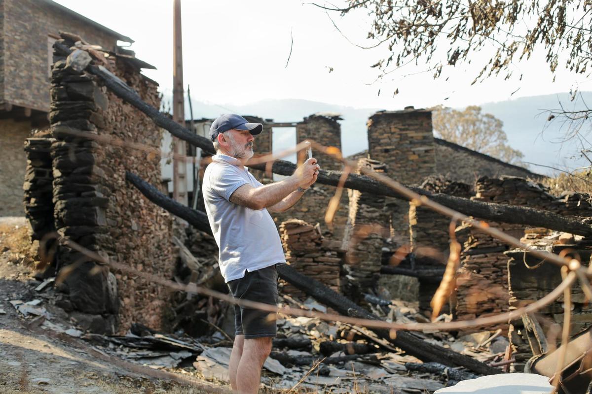 Una individuo fotografía los escombros de la Sierra de Caurel tras el incendio, a 23 de julio de 2022, en Lugo, Galicia, (España). Las hectáreas quemadas en la Sierra de O Courel se mantienen en 10.000. O Courel, es una de las comarcas con mayor valor amb