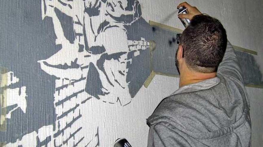 Salvador Gómez trabajando en una de sus obras de arte-pop callejero