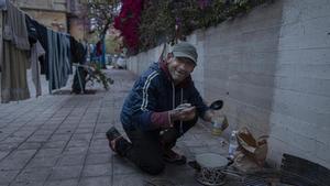 Una persona en situación de sinhogarismo de Valencia prepara un caldo, en 2021.