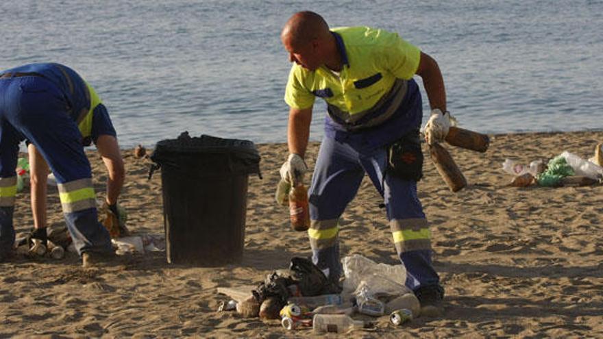Operarios de Limasa se afanan en la limpieza de una playa.